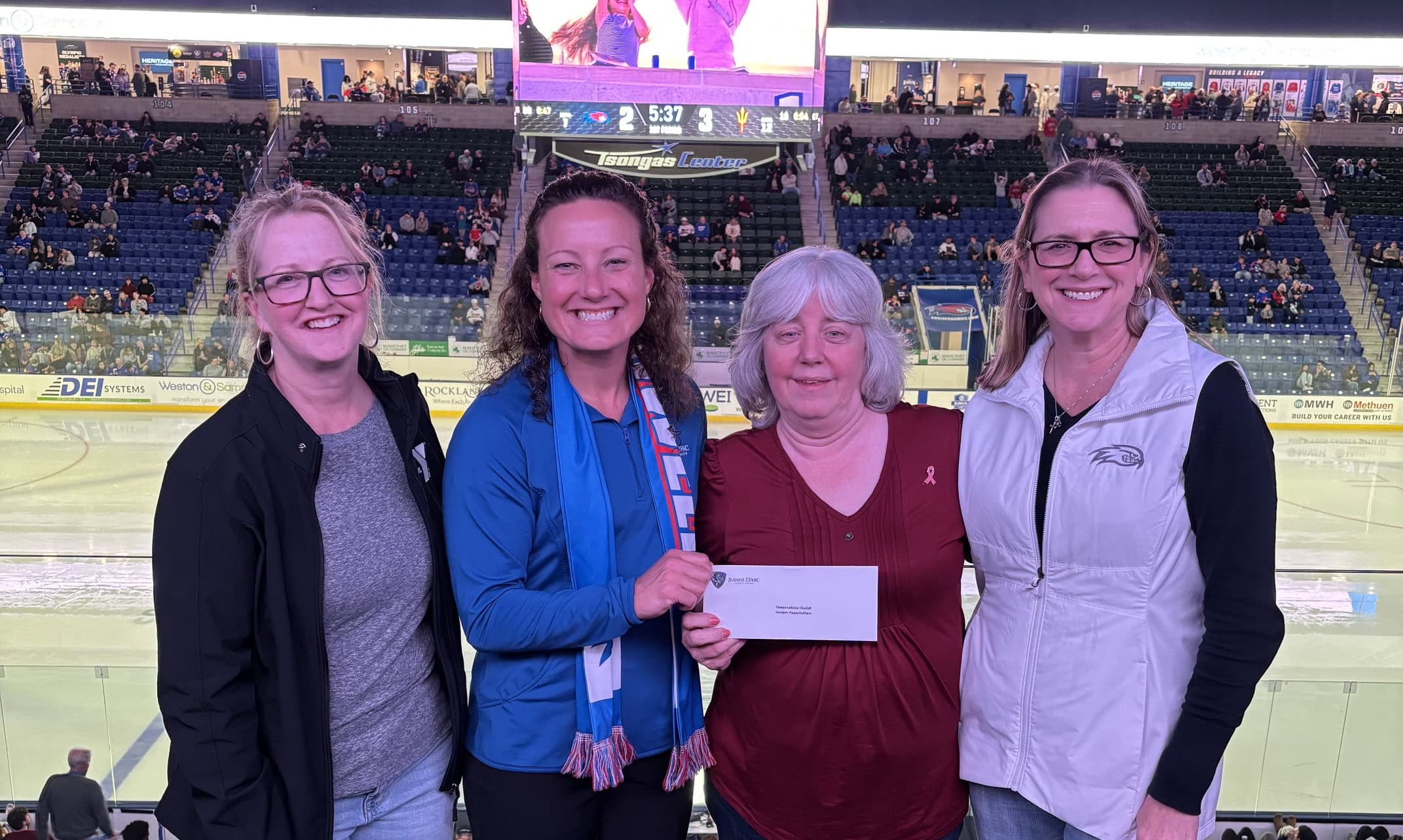 Kathryn Dame, Vice President, Branch Administration, Larissa Thurston, President & CEO, and Alison Hughes, Vice President, Community Engagement at Jeanne D’Arc Credit Union presenting a donation to Dawn Roberts, Vice President of Finance & Administration (second from the right) of Cooperative Credit Union Association - A Bed for Every Child.