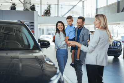 A family talking to a representative at a car dealership.