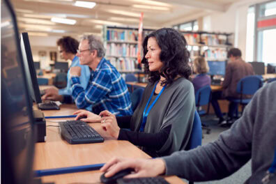 Several people using public computers at a public library.