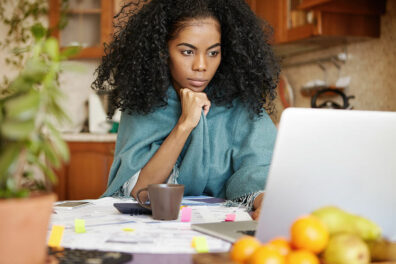 a woman reviews options for personal loans and personal lines of credit on her laptop.