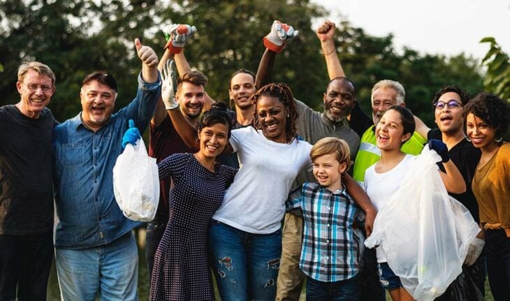 A group of credit union members performing charitable work at a local park.