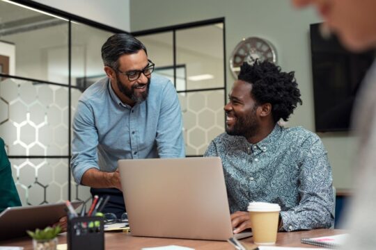 Two business partners discuss the benefits of a business credit card.