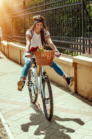 A happy confident woman rides her bike with no feet on the pedals. She was able to regain her confidence and financial independence thanks to a JDCU rebuilder personal loan.