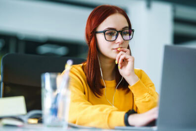 Young woman works at a laptop in the office.