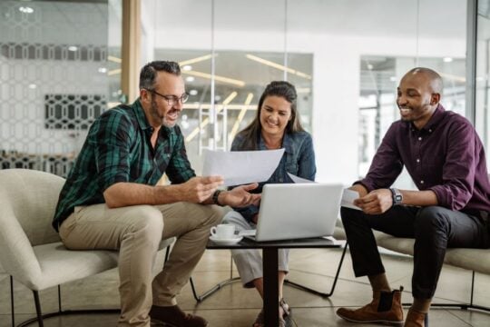 Three business partners discuss business loan options.