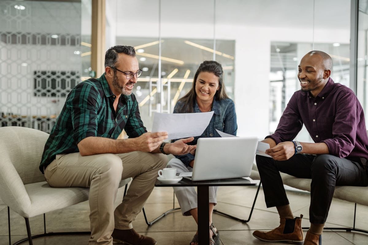 Three business partners discuss business loan options.