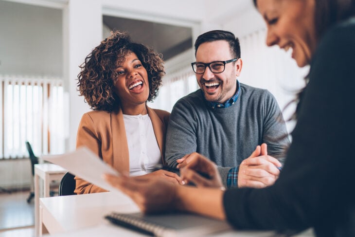 Happy couple talks with loan officer