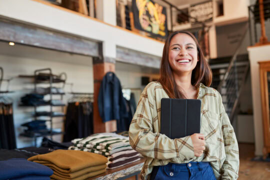 A clothing boutique owner smiles about the success of her small business.