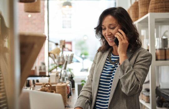 A small business owner talks on the phone with a customer.
