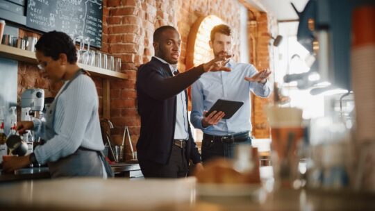A manager works with his employees in a restaurant