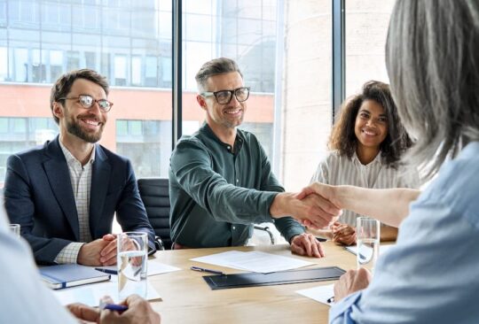 A group of businesspeople meet with a mentor in an office