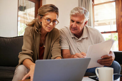 An older couple reviews IRA contribution limits 2023 online.