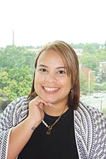 Headshot of Christian Caraballo, Jeanne D'Arc Member Service Representative. She is resting her hand under her chin and smiling at the camera.