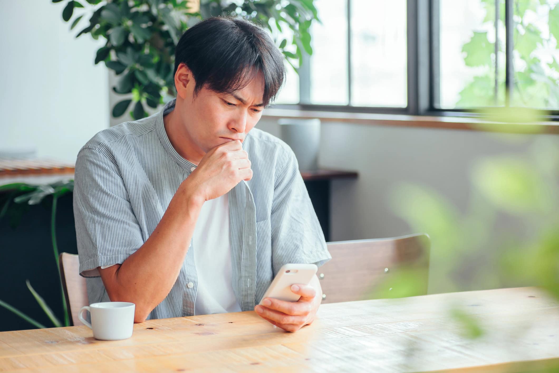 A man feeling down while looking at his smartphone.
