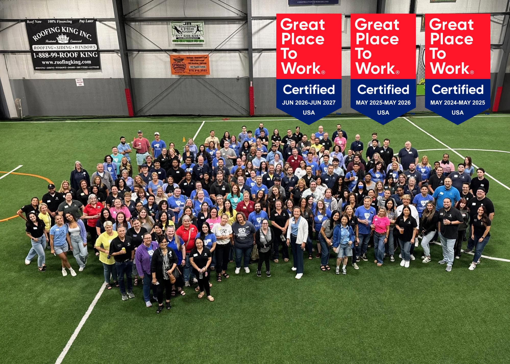 Group picture of Jeanne D'Arc employees with three Great Place to Work badges in the upper right corner of the image.