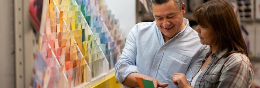 Portrait of a loving couple at home improvement choosing a color to paint their house and holding a palette - decoration concepts