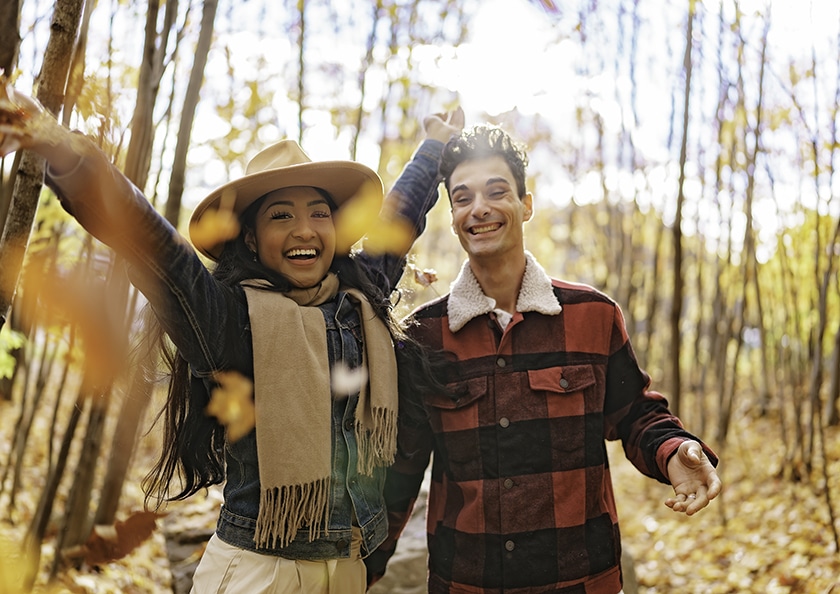 Young beautiful couple in the autumn garden at fall.