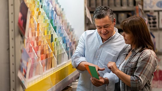 Portrait of a loving couple at home improvement choosing a color to paint their house and holding a palette - decoration concepts