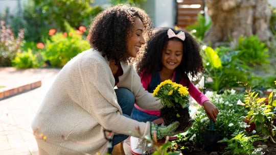 Happy mother and daughter planting flowers. family time, having fun together at home and garden