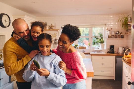 Teen girl looking at selfie on phone with family