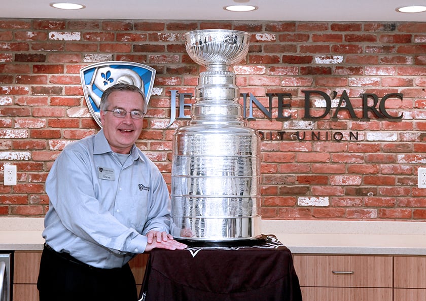 Man standing next to the Stanley Cup Trophy