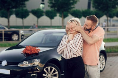 a man surprises a woman with a new vehicle