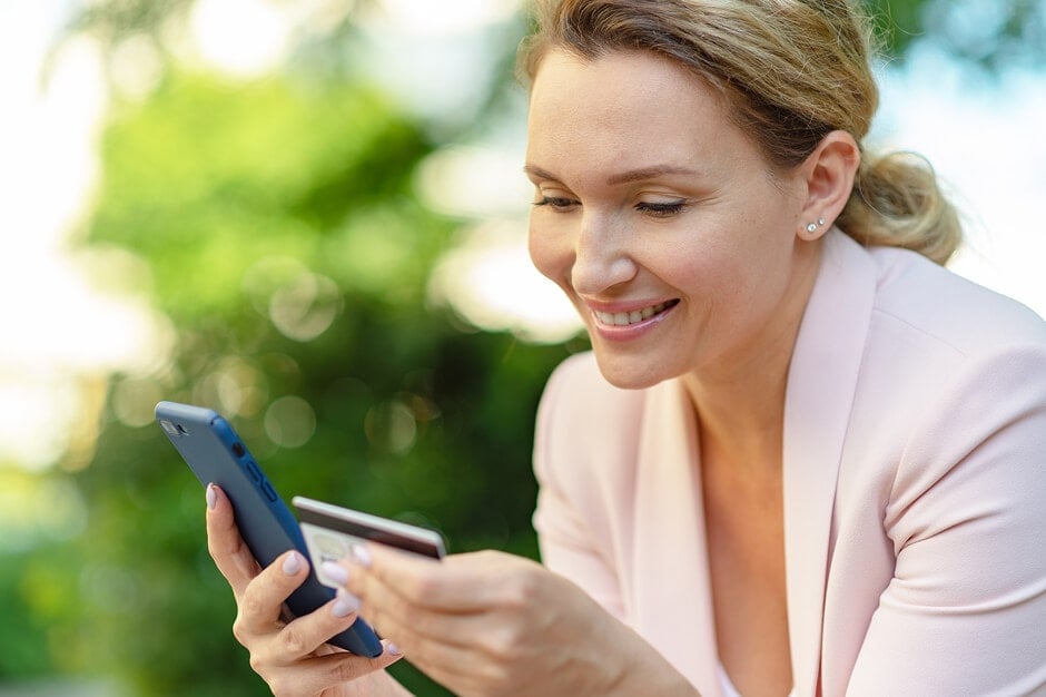 a woman building credit with her credit card by making a purchase on her smartphone