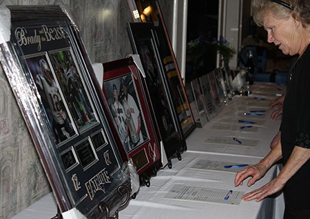 Woman looking at items up for auction at the Jeanne D'Arc Credit Union annual fundraiser