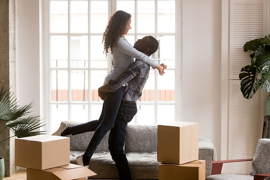 a happy couple embracing and celebrating the purchase of their first home