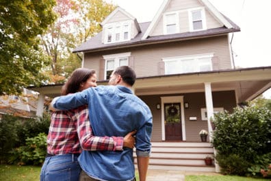 A couple walking together up to a house