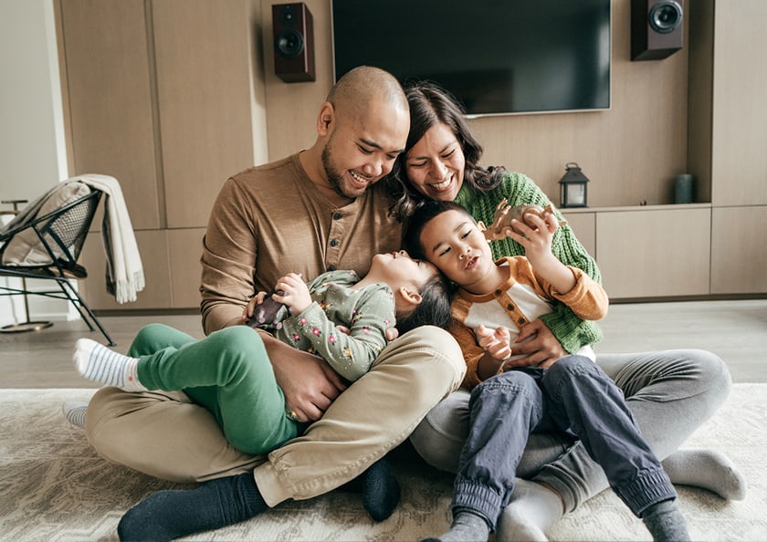 Family cuddling on living room floor