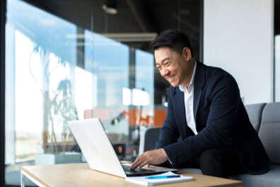 Senior Asian business man working on laptop online.