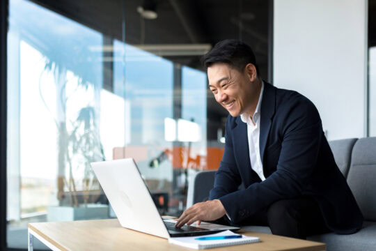 Senior Asian business man working on laptop online.