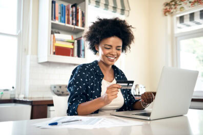 A young Black woman working on her personal finances and paying her bills.