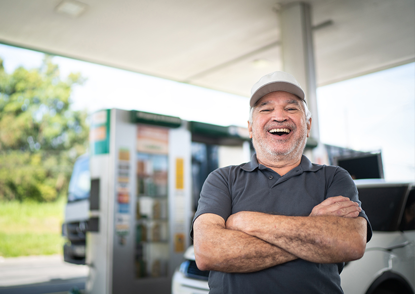 man-smiling-while-putting-gas-in-rv-Hero