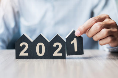 a man placing number blocks shaped like houses to display 2021