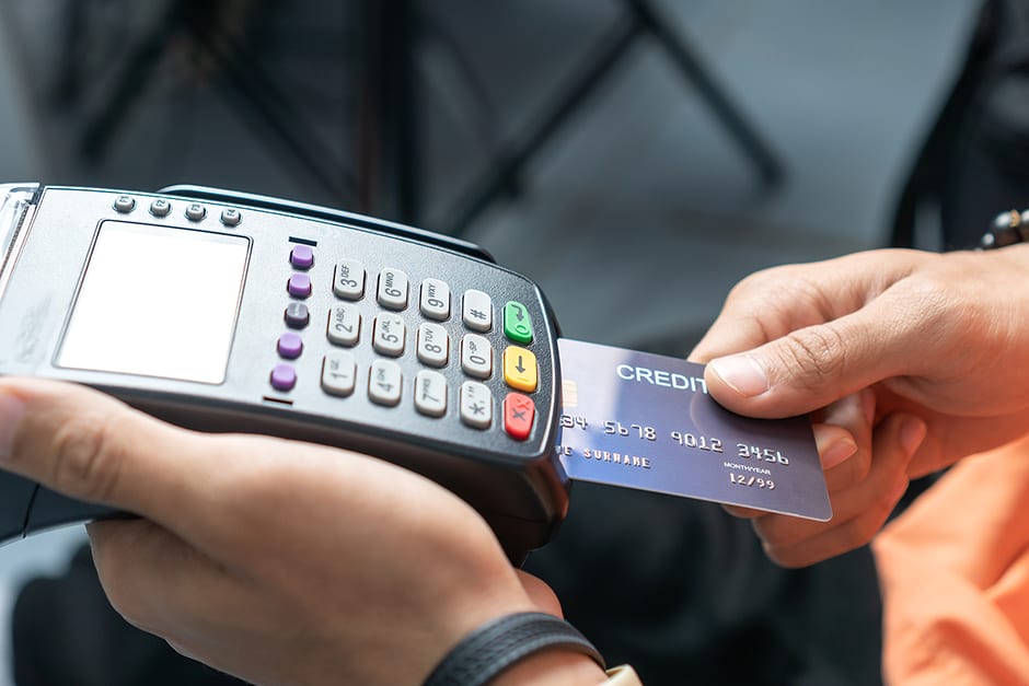 A credit card being inserted into a payment processor