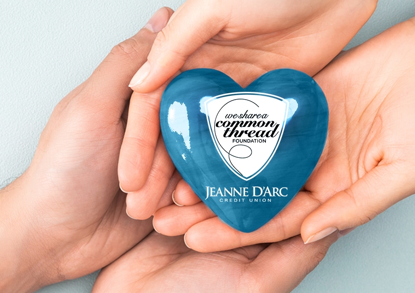 A woman's and a man's hands holding a blue heart. Inside the heart is the We Share A Common Thread Foundation logo.